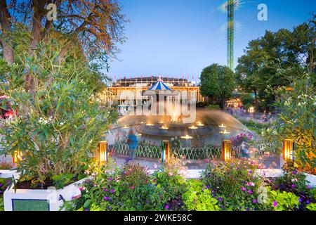 Fontana da giardino, giostra in vecchio stile e sala concerti nello storico parco divertimenti - Tivoli Gardens a Copenhagen, Danimarca Foto Stock