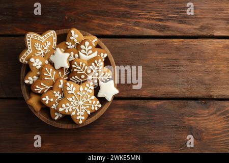 Gustosi biscotti di Natale con glassa nel recipiente su un tavolo di legno, vista dall'alto. Spazio per il testo Foto Stock