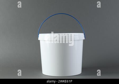 Un secchio in plastica con coperchio su sfondo grigio Foto Stock