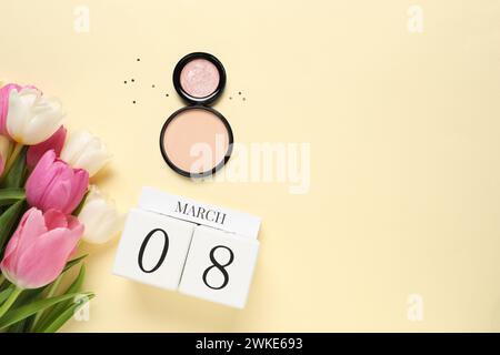 Giornata internazionale della donna - 8 marzo. Prodotti cosmetici, calendario a blocchi di legno, splendidi fiori su sfondo beige, posa piatta. Spazio per il testo Foto Stock