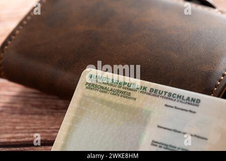 Augusta, Baviera, Germania - 18 febbraio 2024: Carta d'identità della Repubblica Federale di Germania accanto ad un portafoglio *** Personalausweis der Bundesrepublik Deutschland neben einem Geldbeutel Foto Stock