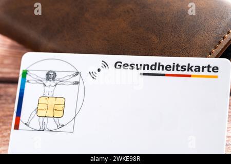 Augusta, Baviera, Germania - 18 febbraio 2024: Tessera di assicurazione sanitaria accanto ad un portafoglio *** Gesundheitskarte einer Krankenkasse neben einer Geldbörse Foto Stock
