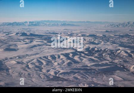 Il cielo con le nuvole e le montagne nella neve. Foto scattata da un aereo. Foto Stock