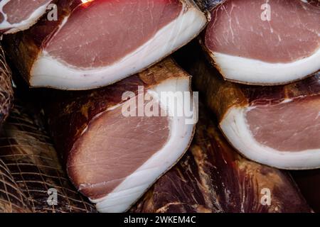 Deliziosi pezzi di carne affumicata esposti per la vendita nel mercato presentato per la vendita in un mercato agricolo nel villaggio di Kacarevo, pancetta gastro e carne secca Foto Stock