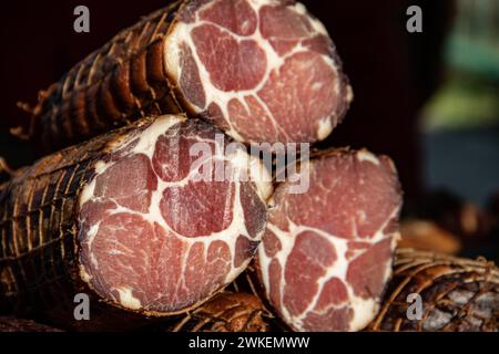 Deliziosi pezzi di carne affumicata esposti per la vendita nel mercato presentato per la vendita in un mercato agricolo nel villaggio di Kacarevo, pancetta gastro e carne secca Foto Stock