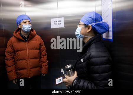 (240220) -- PECHINO, 20 febbraio 2024 (Xinhua) -- Zhu Rui (L) parla con un medico sull'uso delle attrezzature per PTOM presso l'ospedale Pechino Anzhen di Pechino, capitale della Cina, 18 febbraio 2024. Il 18 febbraio, il primo giorno lavorativo dopo la festa di primavera della Cina, Zhu Rui, fondatore della società di dispositivi medici Vivolight, è venuto nella sala operatoria del catetere dell'ospedale Pechino Anzhen per conoscere l'uso delle apparecchiature OCT prodotte dalla sua azienda. La tecnologia di tomografia OCT (Optical Coherence Tomography) consente ai medici di esaminare i pazienti e visualizzare immagini tridimensionali in tempo reale in cui passa il catetere, pr Foto Stock