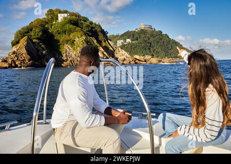 Barca per gite turistiche nella baia di la Concha, dietro l'isola di Santa Clara e il monte Igeldo, Donostia, San Sebastian, Paesi Baschi, Spagna Foto Stock