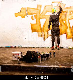 Artisti di strada che dipingono graffiti nel Leake Street Tunnel, Londra. Foto Stock