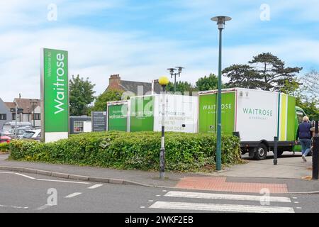 Cartello d'ingresso del supermercato Waitrose parcheggiato furgoni e clienti parcheggiano i clienti. I clienti fanno acquisti in un parcheggio pedonale da Street Billericay Essex Inghilterra Regno Unito Foto Stock