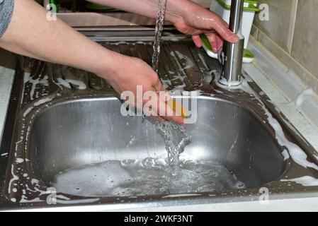 Primo piano delle mani della donna mentre le lavo sotto l'acqua corrente. Foto di alta qualità Foto Stock