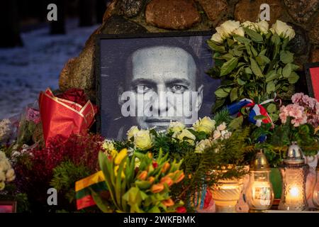 Fiori e candele posate al memoriale spontaneo per il leader dell'opposizione russa Alexei Navalny, con un ritratto in bianco e nero bagnato dalla neve Foto Stock