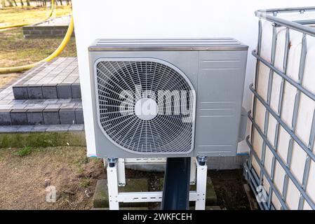 Unità esterna di una pompa di calore dell'aria a bassa potenza situata di fronte all'abitazione. Foto Stock