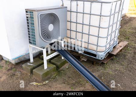 Unità esterna di una pompa di calore dell'aria a bassa potenza situata di fronte all'abitazione. Foto Stock