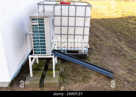 Unità esterna di una pompa di calore dell'aria a bassa potenza situata di fronte all'abitazione. Foto Stock