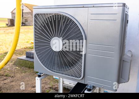 Unità esterna di una pompa di calore dell'aria a bassa potenza situata di fronte all'abitazione. Foto Stock