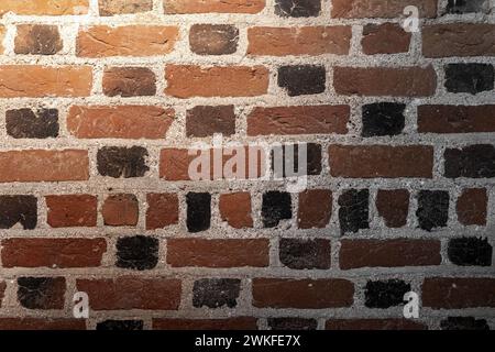 Antico muro di mattoni scuri con faretti e texture fotografica di sfondo Foto Stock