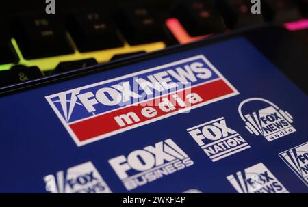 Viersen, Germania - 9 gennaio. 2024: Primo piano del telefono cellulare con il canale Fox news sulla tastiera del computer Foto Stock