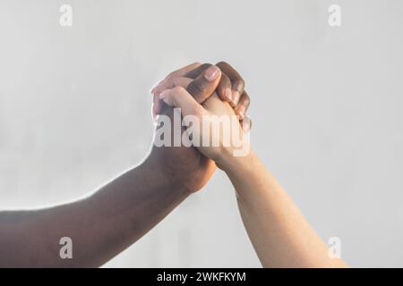Primo piano delle mani di un uomo afroamericano e di una donna caucasica, che si tiene per mano, si unisce per mano Foto Stock