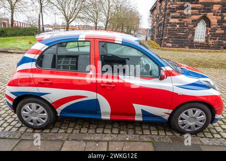 Una Nissan Micra con bandiera dell'Unione colorata a Warrington parcheggiata in una strada di Setts Foto Stock