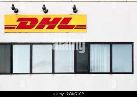 Fredericia, Danimarca - 27 marzo 2022: Logo DHL su una facciata. DHL Express è una divisione della società tedesca di logistica Deutsche Post DHL Foto Stock