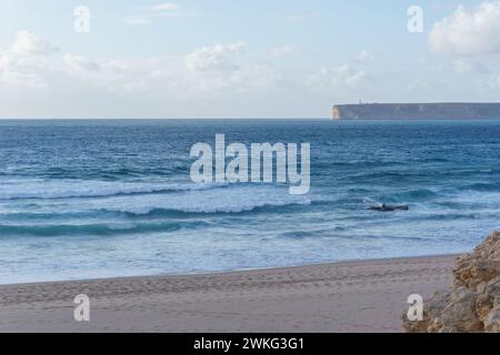 Vista sul mare dalla spiaggia di Praia do Tonel a capo Sao Vicente con faro, Sagres, Algarve, Portogallo Foto Stock