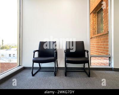 Due sedie vuote fuori dallo studio medico, dallo studio dentista o dalla sala d'attesa dell'ufficio del terapista Foto Stock