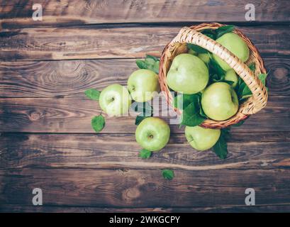 cestino pieno di mele mature in un giardino. Vendemmia di mele. Concetto autunnale. Mele fresche. Mele come sfondo per i designer. Un sacco di mele. Foglie di a. Foto Stock