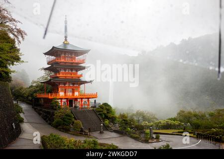 Pagoda del Tempio di Seiganto-ji con le Cascate Nachi alle spalle in un giorno di pioggia, aprile, Giappone Foto Stock