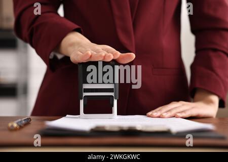 Documento di timbratura notaio a tavola in ufficio, primo piano Foto Stock