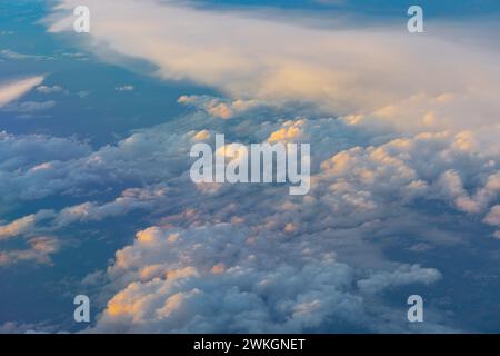 Luce solare attraverso le nuvole nel vasto cielo blu, vista dalla finestra di un aereo Foto Stock