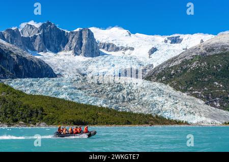 Passeggeri della nave da crociera Stella Australis che viaggiano su un gommone di gomma di fronte al ghiacciaio Pia, Parco Nazionale Alberto de Agostini, Avenue Foto Stock