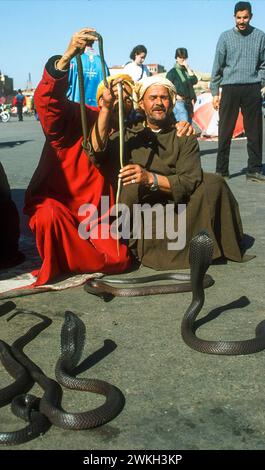 Marrakech, Marocco. Incantatori di serpenti che si esibiscono nella Djemaa El Fna Foto Stock