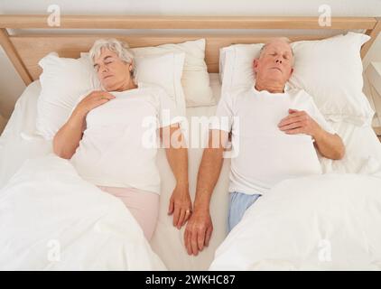 Dormire, amare e coppia anziana a letto, riposare e rilassarsi insieme durante il fine settimana in camera. Anziani, pensionamento e sogno a casa, top Foto Stock