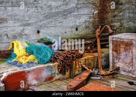 Vecchia ancora arrugginita e catena su una banchina Foto Stock