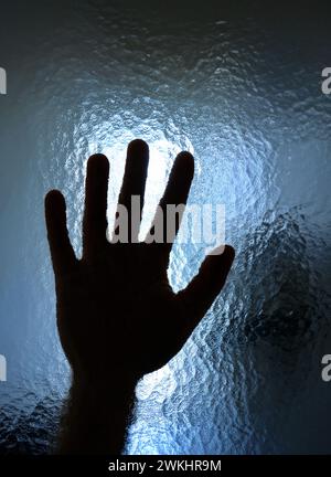 Profilo maschio a palmo aperto dietro vetro smerigliato blu. Immagine concettuale, persona irriconoscibile. Foto Stock
