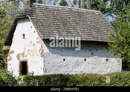 Vecchio granaio nel villaggio polacco con tetto in piastrelle di legno e facciata in argilla bianca calcarea. Ex villaggio tedesco nella regione di Opole, Polonia Foto Stock