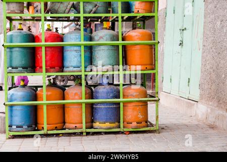 Bombole colorate di gas propano-butano conservate su ripiani in acciaio. Bombole di gas naturale nella stazione di servizio di Marrakech, Marocco. Foto Stock