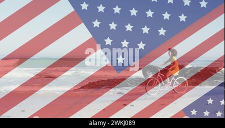 Immagine della bandiera americana che rivela la statua della libertà e la donna che cavalca in bicicletta sulla spiaggia Foto Stock