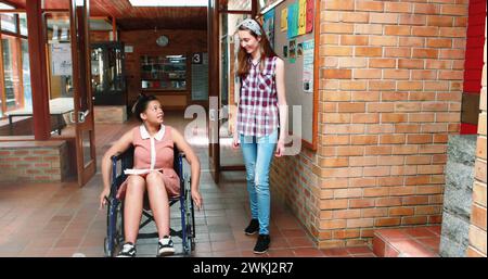 Immagine di spot luminosi su studenti birazziali disabili con un amico Foto Stock