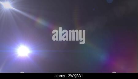 Immagine di riflettori con luce parassita sull'obiettivo su sfondo scuro Foto Stock