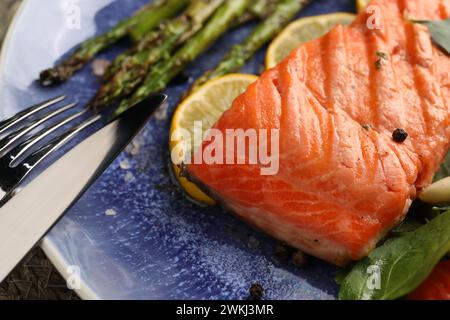 Gustoso salmone alla griglia con asparagi, limone e spezie serviti al tavolo, primo piano Foto Stock