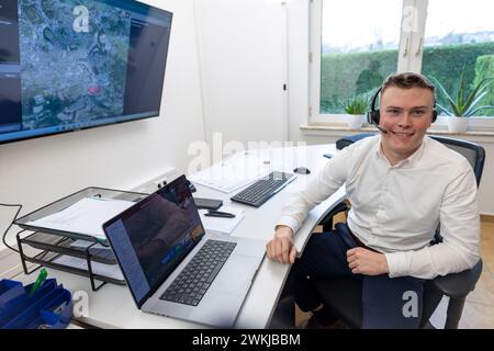 21 febbraio 2024, Renania settentrionale-Vestfalia, Lüdenscheid: Il pilota Yanick Schmid siede in una stazione di controllo di fronte agli schermi utilizzati per lanciare e monitorare i voli di consegna con i droni. Una flotta di droni completamente automatizzata è quella di consegnare le parti urgentemente necessarie dall'aria alle compagnie di Lüdenscheid, che è stata duramente colpita dal disastro del ponte A45-Rahmede. Foto: Christoph Reichwein/dpa Foto Stock