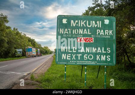 Camion sul lato dell'autostrada A7 vicino al cartello di ingresso al Parco Nazionale di Mikumi in Tanzania Foto Stock