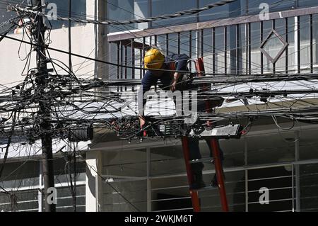 Elektriker auf einer Leiter arbeitet an der massiven Verkabelung im Stadtteil Roma, Mexiko Stadt Foto Stock