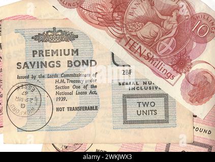 Primo piano di una Premium Savings Bond vintage da £2 e una banconota da dieci scellini del Regno Unito su sfondo bianco. Foto Stock