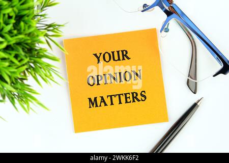 LA TUA OPINIONE CONTA una frase scritta su un adesivo arancione su sfondo bianco Foto Stock