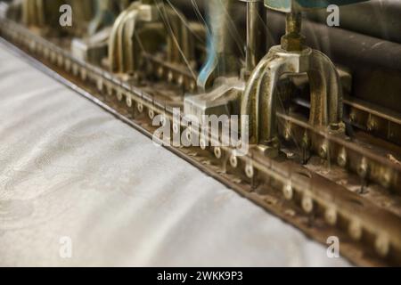Industrial Textile Machine in azione, primo piano sulla tessitura del tessuto Foto Stock