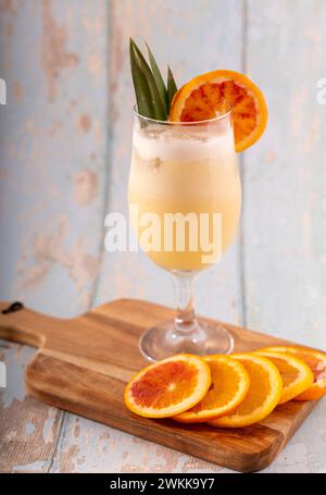 Cocktail Pina colada con contorno e sfondo rustico azzurro Foto Stock