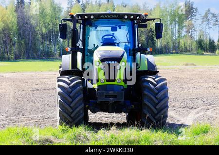 Trattore Claas Axion 850 sul campo in una giornata di sole primaverile, vista frontale. Salo, Finlandia. 20 maggio 2023. Foto Stock