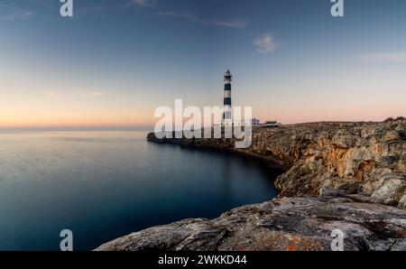 Una vista del faro di Cap d'Artrutx sull'isola di Minorca subito dopo l'alba Foto Stock